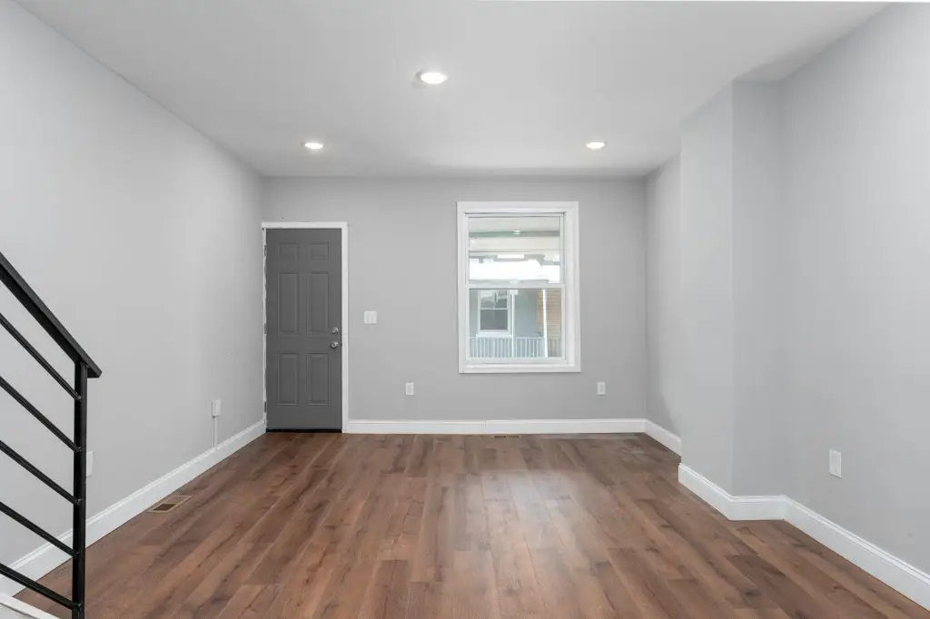 Minimalist entryway and living area featuring wide-plank wood floors, neutral paint tones, and recessed lighting in a Philadelphia rowhome.