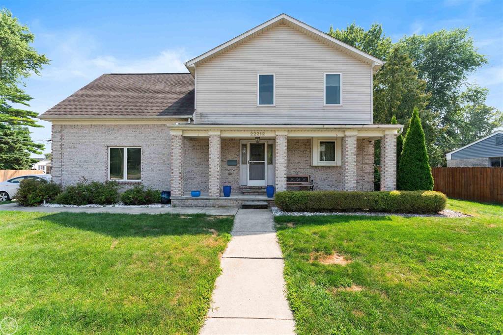 Exterior real estate photo of 22212 Mylls Ct in St. Clair Shores showing covered porch, brick facade, front lawn, and corner-lot setting.