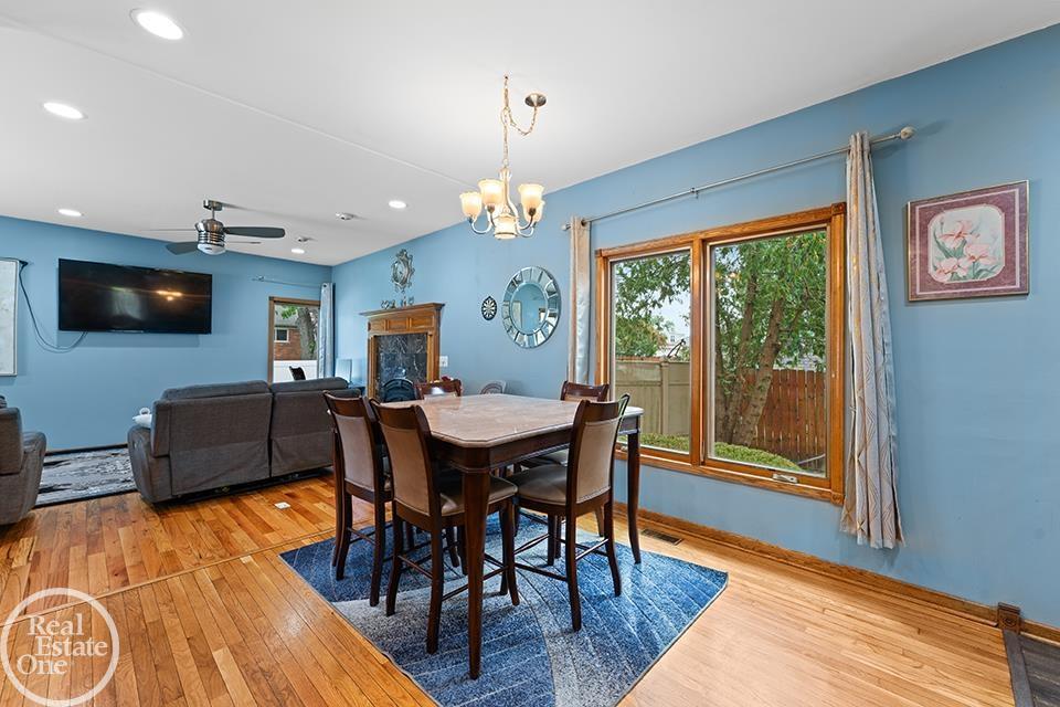 Dining room at 22212 Mylls Ct with large window, blue walls, hardwood floors, and open view to living room.