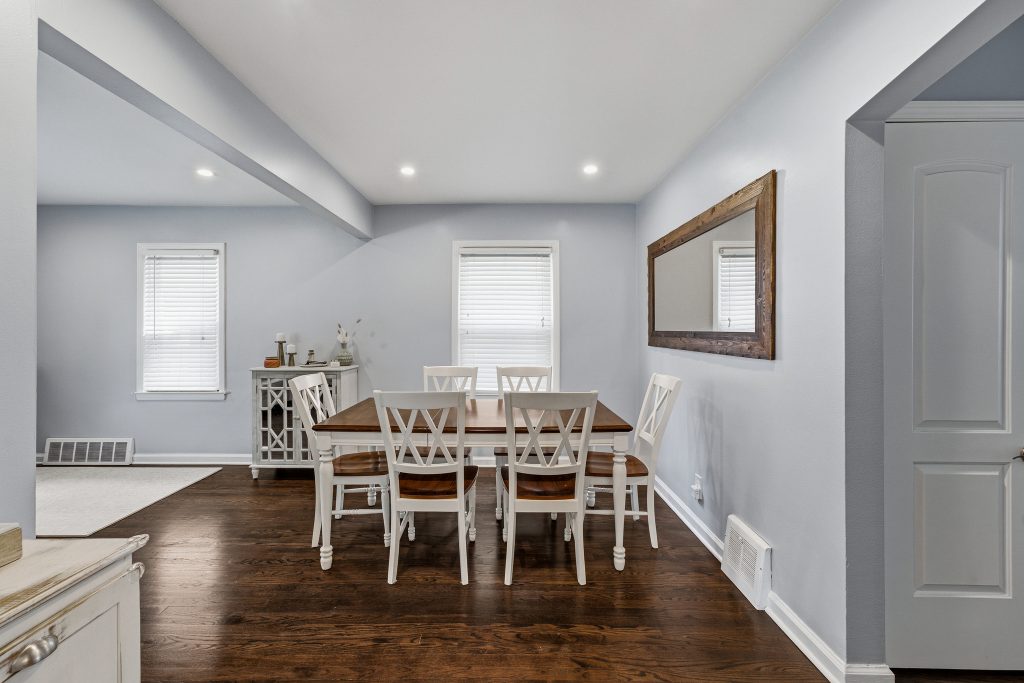 Royal Oak dining room with hardwood floors, wood dining table, gray walls, and wide opening to the living room.