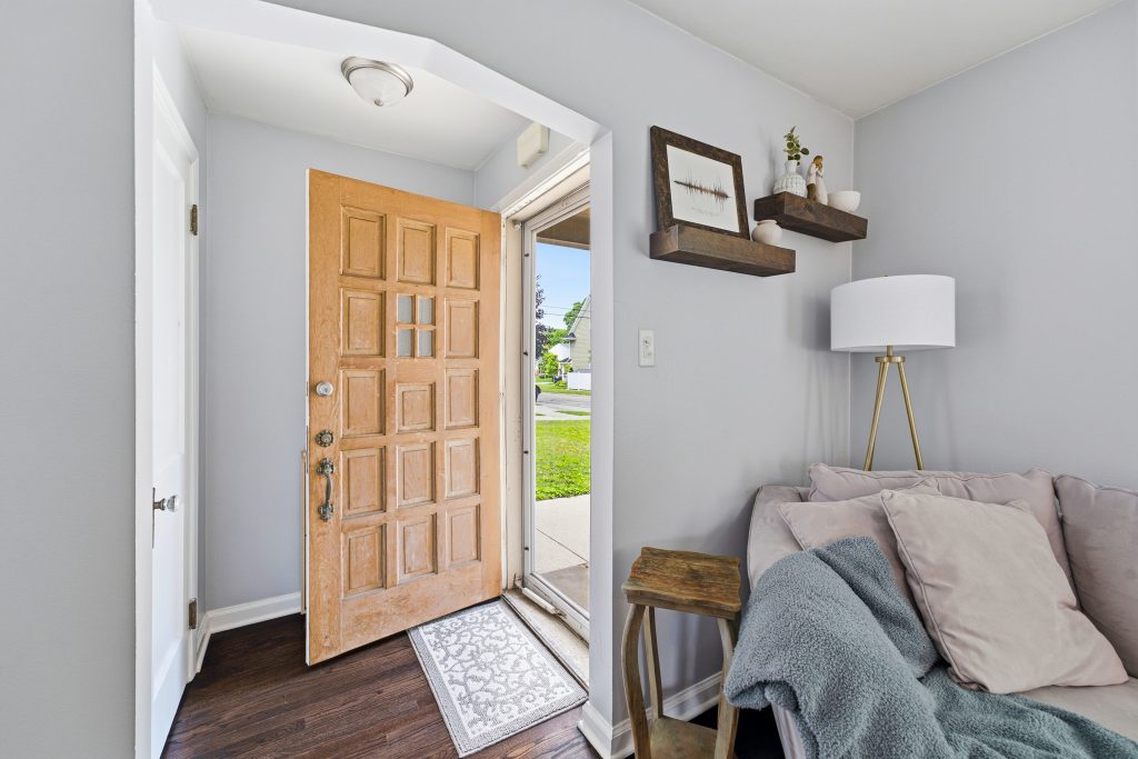 Interior view of a Royal Oak home showing the open wood front door and adjoining living room.