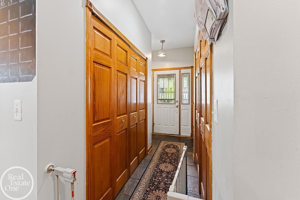 Entry foyer at 22212 Mylls Ct in St. Clair Shores with wood trim, built-in storage, front door, and tile flooring.