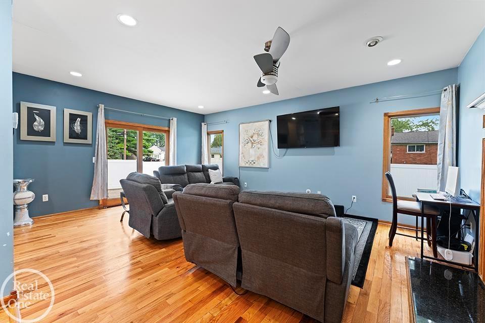 St. Clair Shores living room with hardwood floors, blue walls, large windows, and sectional seating.